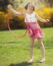 Young girl using hula hoop on arm in a park