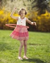 Young girl using hula hoop in a park