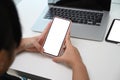 Young girl using mobile phone while sitting in front of her laptop computer at home. Royalty Free Stock Photo