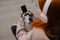 Young girl using mobile phone while sitting outdoors Royalty Free Stock Photo