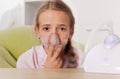 Young girl using a nebulizer inhaler device with mist shooting out of the mouthpiece