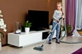 Young girl vacuuming room