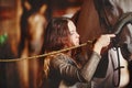 A young girl in a village stables saddles her horse.