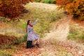 Young girl waiting on a country road with her suitcase. Royalty Free Stock Photo