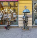 A young girl is waiting for someone near the monument to the photographer