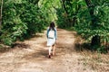 young girl walking along a sandy path in the city park