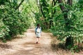 young girl walking along a sandy path in the city park