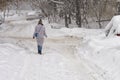 Girl walking along a snowbound Moscow street in February