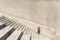 Young girl walking down the stairs Stone steps at the city Baku Azerbaijan. Concrete staircase with concrete wall side