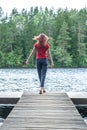 Young girl walking on the pier, back to the camera. A view of the beautiful lake. Summer mood Royalty Free Stock Photo