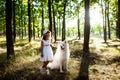 Young girl walking, playing with dog in park at sunset. Royalty Free Stock Photo