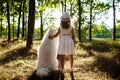 Young girl walking, playing with dog in park at sunset. Royalty Free Stock Photo