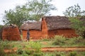 Young girl walking in traditional african village, Kenya