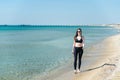 A young girl walks along the beach after a run in sunglasses Royalty Free Stock Photo