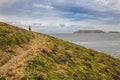 Young girl walks along a colorful coastal path with views of the sea and the sisargas islands. Lighthouses Trail Royalty Free Stock Photo