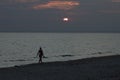 A young girl walks along an empty beach, walks along the coastline at sunset Royalty Free Stock Photo