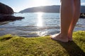 A young girl walks barefoot on the beach. Girl`s legs in the water in the sunlight. Royalty Free Stock Photo