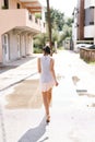 Young girl walks barefoot through puddles. Back view Royalty Free Stock Photo