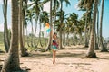 The young girl walks on the beach. Between palms Royalty Free Stock Photo