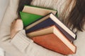 Young girl holds three books in hands