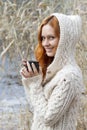 Young girl in warm sweater drinking a cup of hot drink Royalty Free Stock Photo