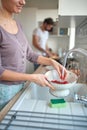 A young girl washing cherry tomatoes in a colander. Vegetables, kitchen, home, food