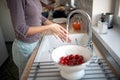 A young girl washing cherry tomatoes for a salad. Vegetables, kitchen, home, food Royalty Free Stock Photo