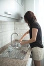 Young girl is washing dishes. The teenager helps with home routine