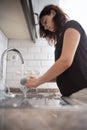 Young girl is washing dishes. The teenager helps with home routine