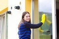 Young girl washing windows Royalty Free Stock Photo