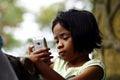 A young girl watches video on a smartphone.