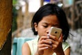 A young girl watches video on a smartphone.