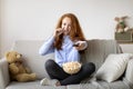 Young girl watching tv eating popcorn in her living room Royalty Free Stock Photo