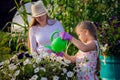 Young girl watering potted flower plant smiling Royalty Free Stock Photo