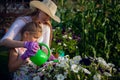 Young girl watering potted flower plant smiling Royalty Free Stock Photo