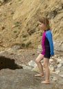 Young girl wearing a colorful swimming suit having fun splashing at the beach Royalty Free Stock Photo