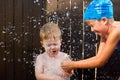 Girl Breaking a Water Balloon on Little Brother Royalty Free Stock Photo
