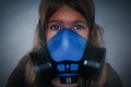 Young girl wearing gasmask, respirator portrait