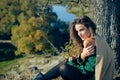 Young girl wearing green sweater sitting under Royalty Free Stock Photo