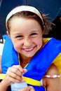 Young girl wearing lifevest holding water bottle.