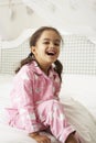 Young Girl Wearing Pajamas Sitting On Bed Royalty Free Stock Photo