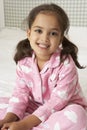 Young Girl Wearing Pajamas Sitting On Bed Royalty Free Stock Photo