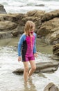 Young girl wearing a mask and colorful swimming suit having fun splashing at the beach Royalty Free Stock Photo