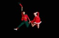 Christmas time, childhood, fairy tale. A young girl wearing a Santa`s costume and boy wearing elf costume flying Royalty Free Stock Photo