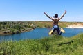 Young girl wearing summer hat  jumping. Young girl outdoors, back view. Royalty Free Stock Photo