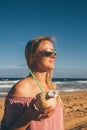 Young girl wearing sunglasses walking down the beach Royalty Free Stock Photo