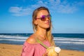 Young girl wearing sunglasses walking down the beach Royalty Free Stock Photo