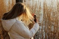 Young girl wearing a white jacket take a picture outdoors. Peole, travel, nature concept. Teenage girl take a photo for Royalty Free Stock Photo