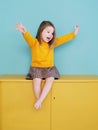 A young girl wearing a yellow shirt