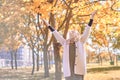 Young girl welcomes autumn. teenager raised her hands up. hello autumn concept